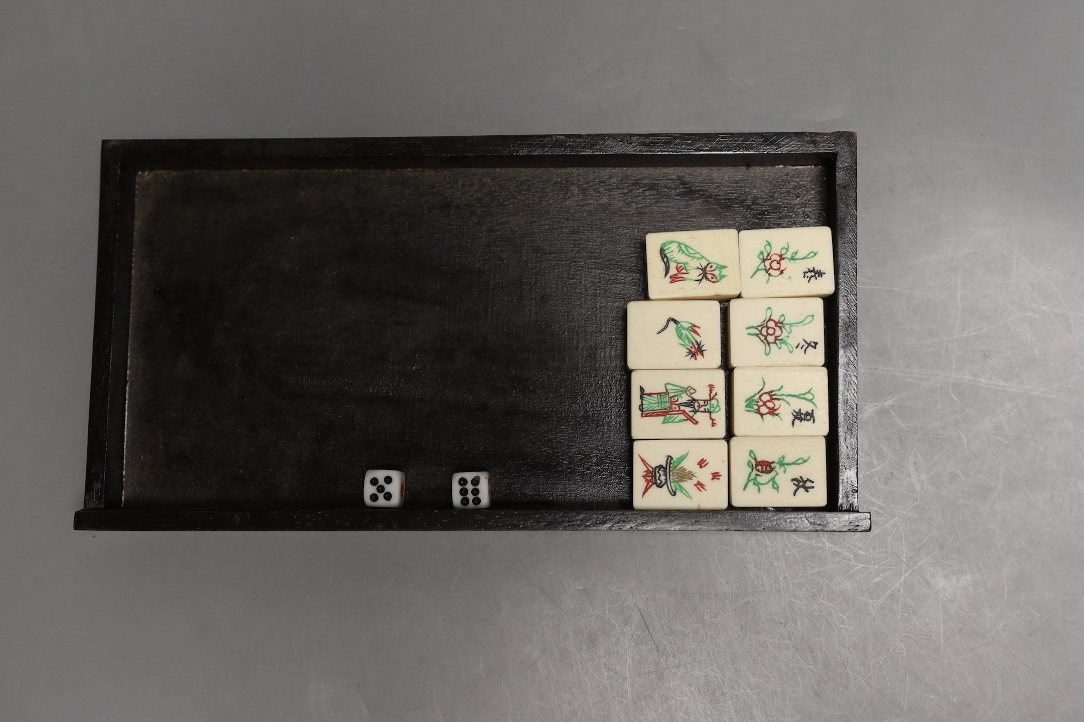 A Chinese boxed mahjong set, bone and bamboo gaming pieces, 24.5 cms wide x 16cms high.
